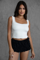 White sleeveless ribbed tank top featuring a low scoop neckline and cropped fit from Tic Toc.