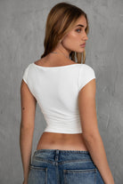 White off-the-shoulder top with stylish ruching and silky fabric by Tic Toc, perfect for casual wear.