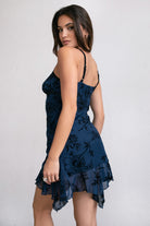 Navy mini dress with floral velvet details and asymmetrical ruffled hem, designed by Tic Toc.