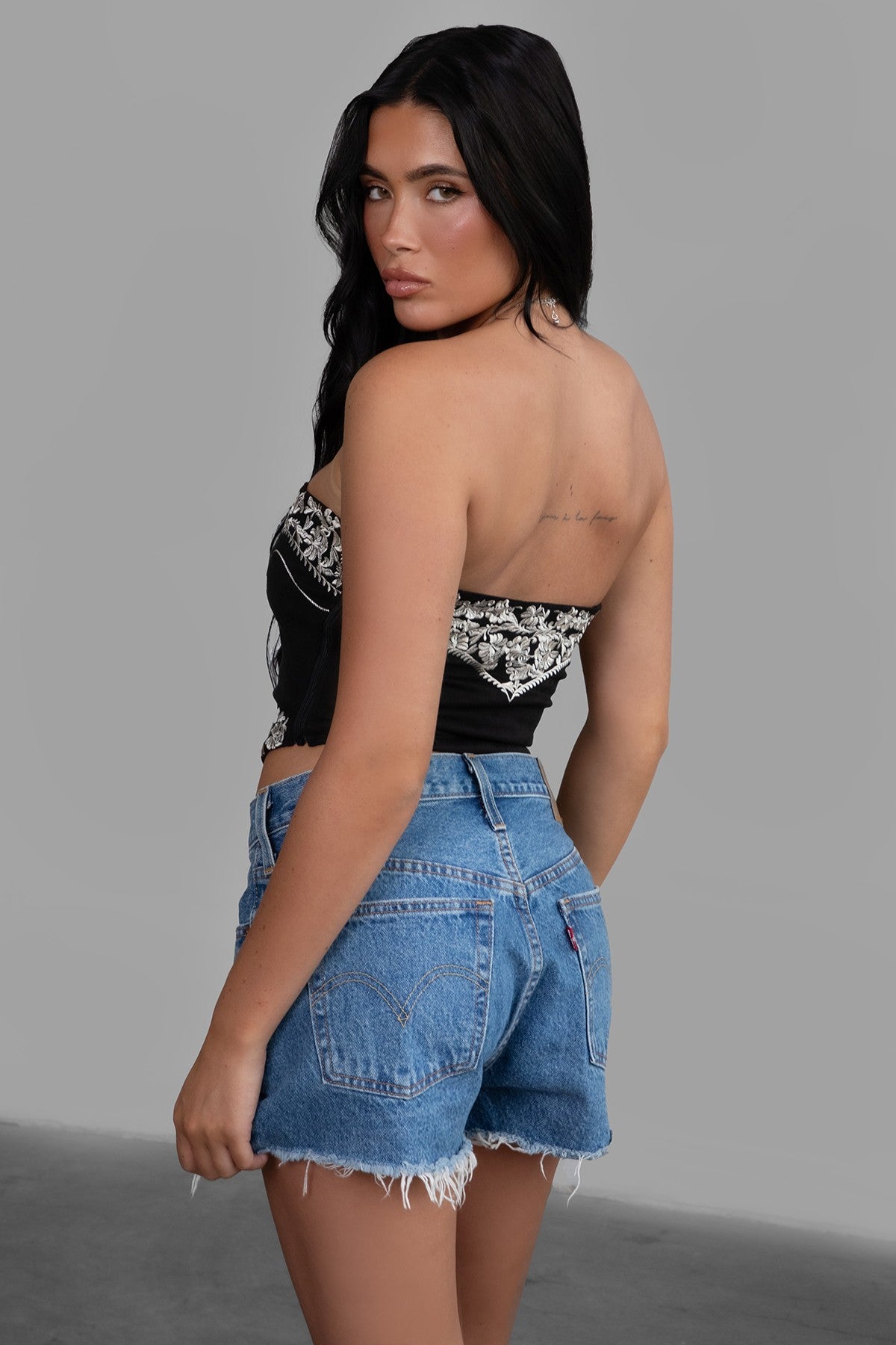 TIC TOC TA30268 MONTANA Embroidered Suede Bustier Top in soft suede with floral embroidery, button-front closure, and asymmetrical hem. Western-inspired festival top