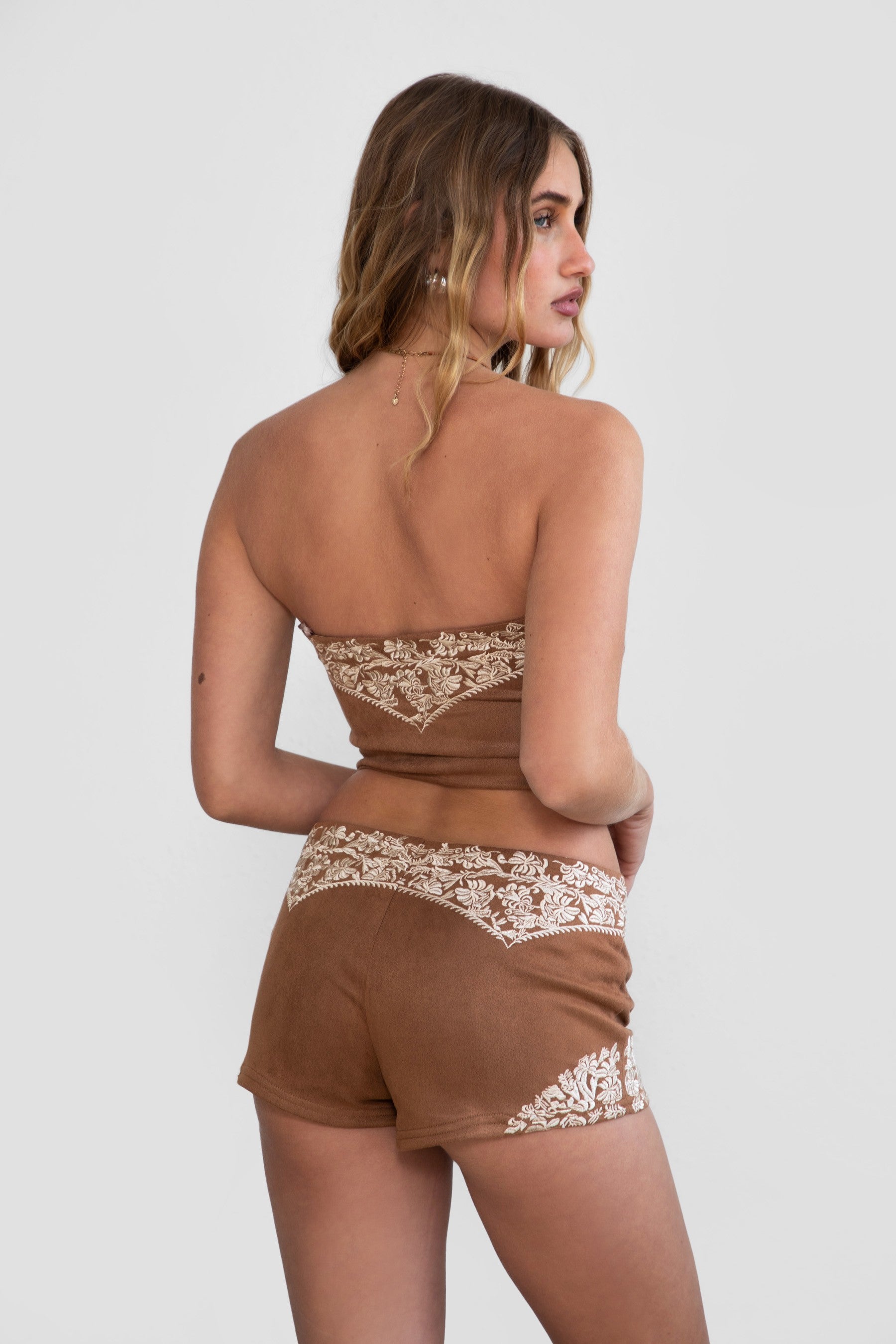 TIC TOC TA30268 MONTANA Embroidered Suede Bustier Top in soft suede with floral embroidery, button-front closure, and asymmetrical hem. Western-inspired festival top