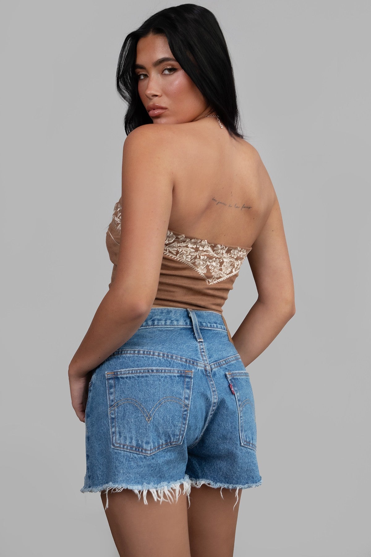 TIC TOC TA30268 MONTANA Embroidered Suede Bustier Top in soft suede with floral embroidery, button-front closure, and asymmetrical hem. Western-inspired festival top