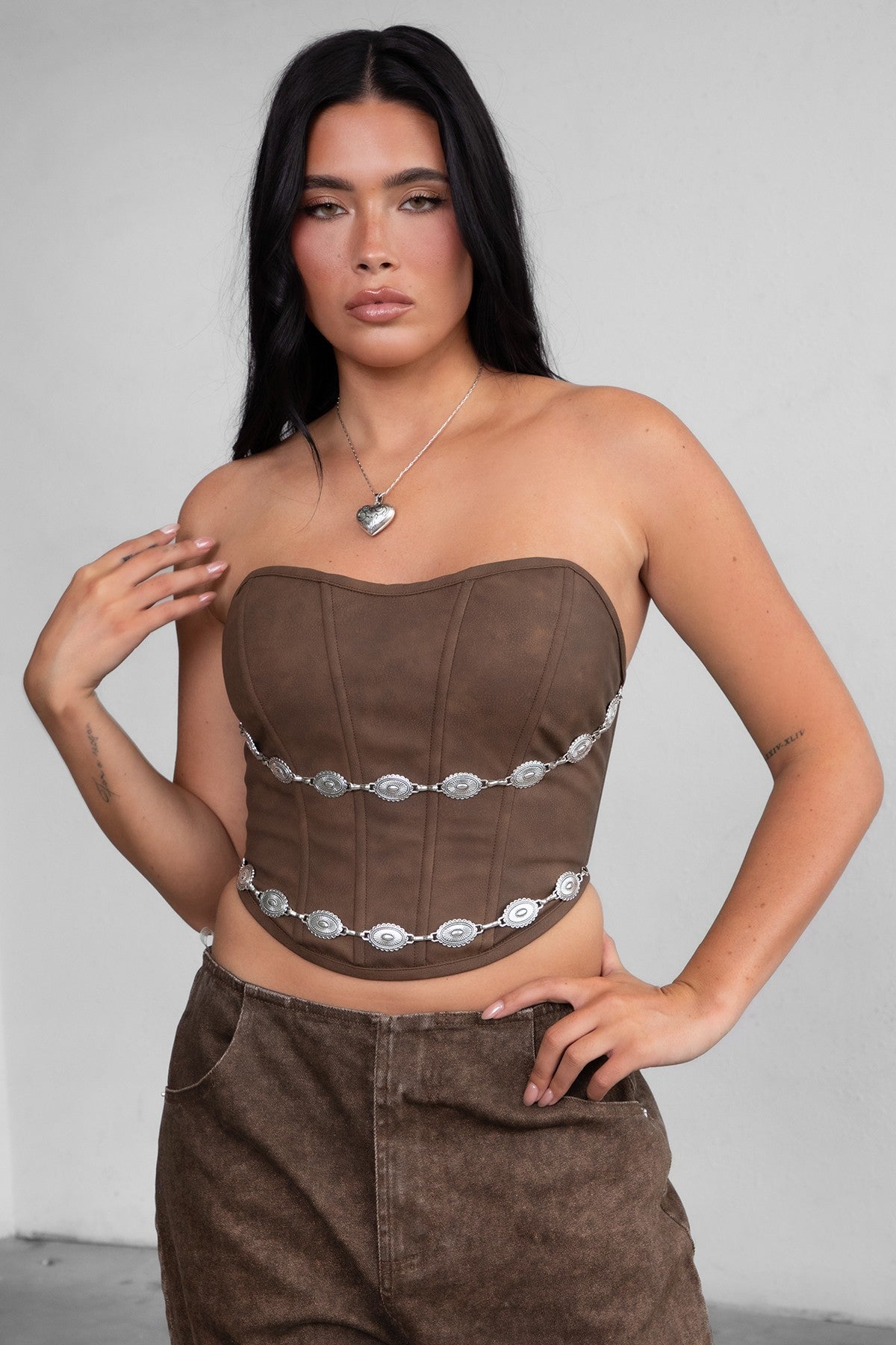 TIC TOC TA30530 GLENDORA Distressed PU Leather Corset Top in brown. Features a sweetheart neckline, boned structure, silver western embellishments, and an adjustable satin lace-up back.