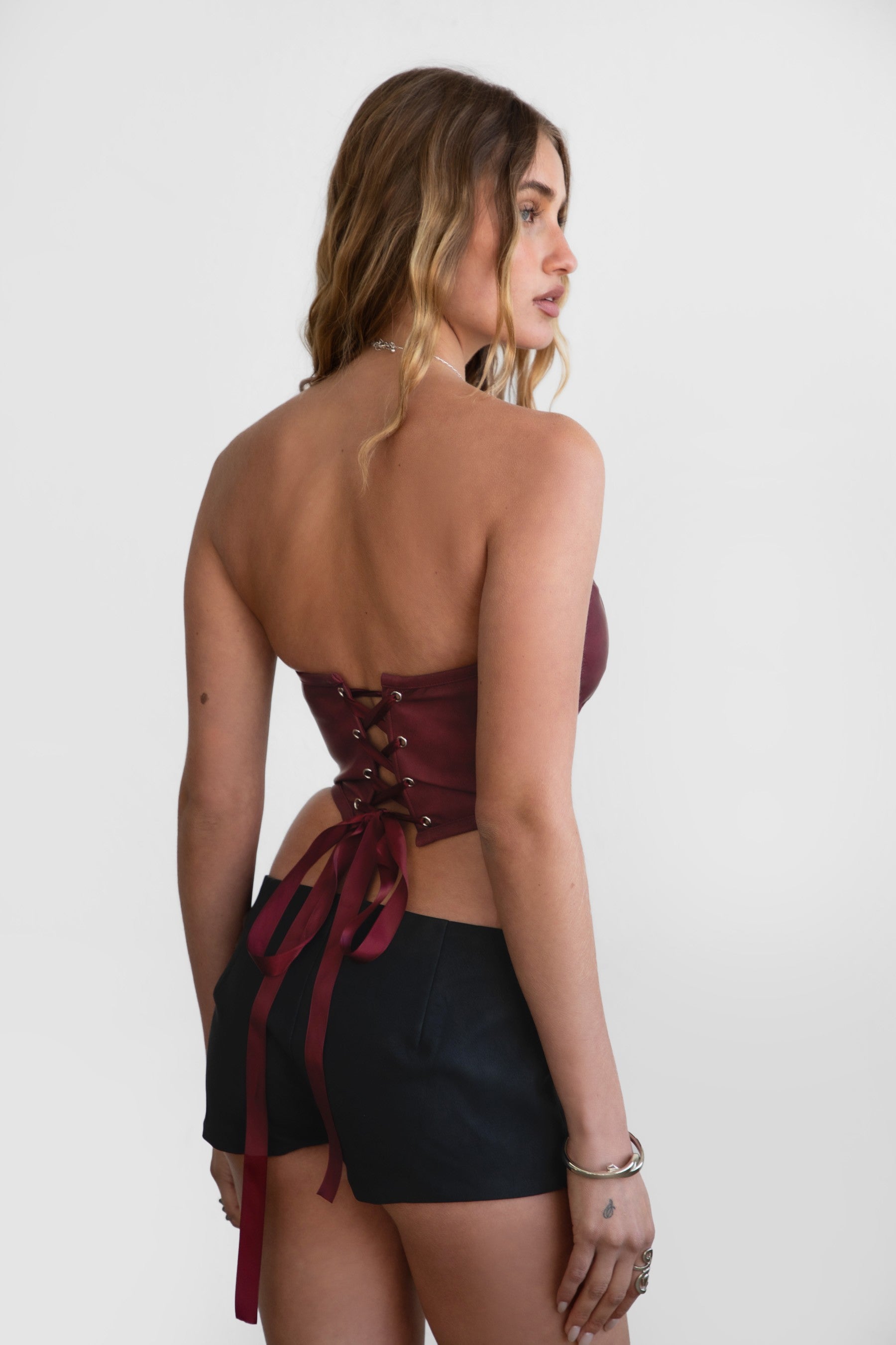 TIC TOC TA30530 GLENDORA Distressed PU Leather Corset Top in red. Features a sweetheart neckline, boned structure, silver western embellishments, and an adjustable satin lace-up back.