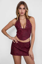 TIC TOC TA30680 DIXY PU Vegan Leather Corset Top. A dark red halter-neck leather top featuring studded details, an exposed back zipper, and a curved hem.