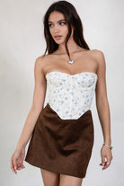 TIC TOC TC30139 GOMEZ Print Eyelet Embroidered Corset Top in brown multi, cream multi, and red. Features a sweetheart neckline, boned panel construction, asymmetrical hem, and adjustable hook-and-eye closure.