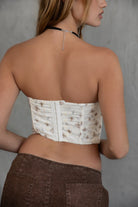 TIC TOC TC30139 GOMEZ Print Eyelet Embroidered Corset Top in brown multi, cream multi, and red. Features a sweetheart neckline, boned panel construction, asymmetrical hem, and adjustable hook-and-eye closure.