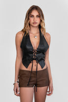 TIC TOC TH30046 CARA Lightweight PU Halter Top in vegan leather. Features a deep V-neckline, halter straps, exposed lace front detail, and a low open back.

