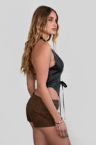 TIC TOC TH30046 CARA Lightweight PU Halter Top in vegan leather. Features a deep V-neckline, halter straps, exposed lace front detail, and a low open back.

