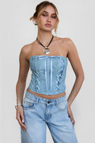 TIC TOC TH30496 ANGIE Distressed PU Corset Top. A strapless leather-look corset with lace-up details, exposed seams, and a satin bow accent.