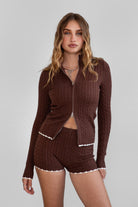 TIC TOC TPC31027 CLINE Cable Knit Two-Piece Lounge Short Set in brown and blush. Features a zip-up cropped sweater with a high mock neck, ribbed contrast trim, and matching mid-rise shorties.