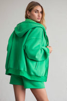 Bright green zip-up hoodie with smooth fleece fabric and side welt pockets for storage by Tic Toc.