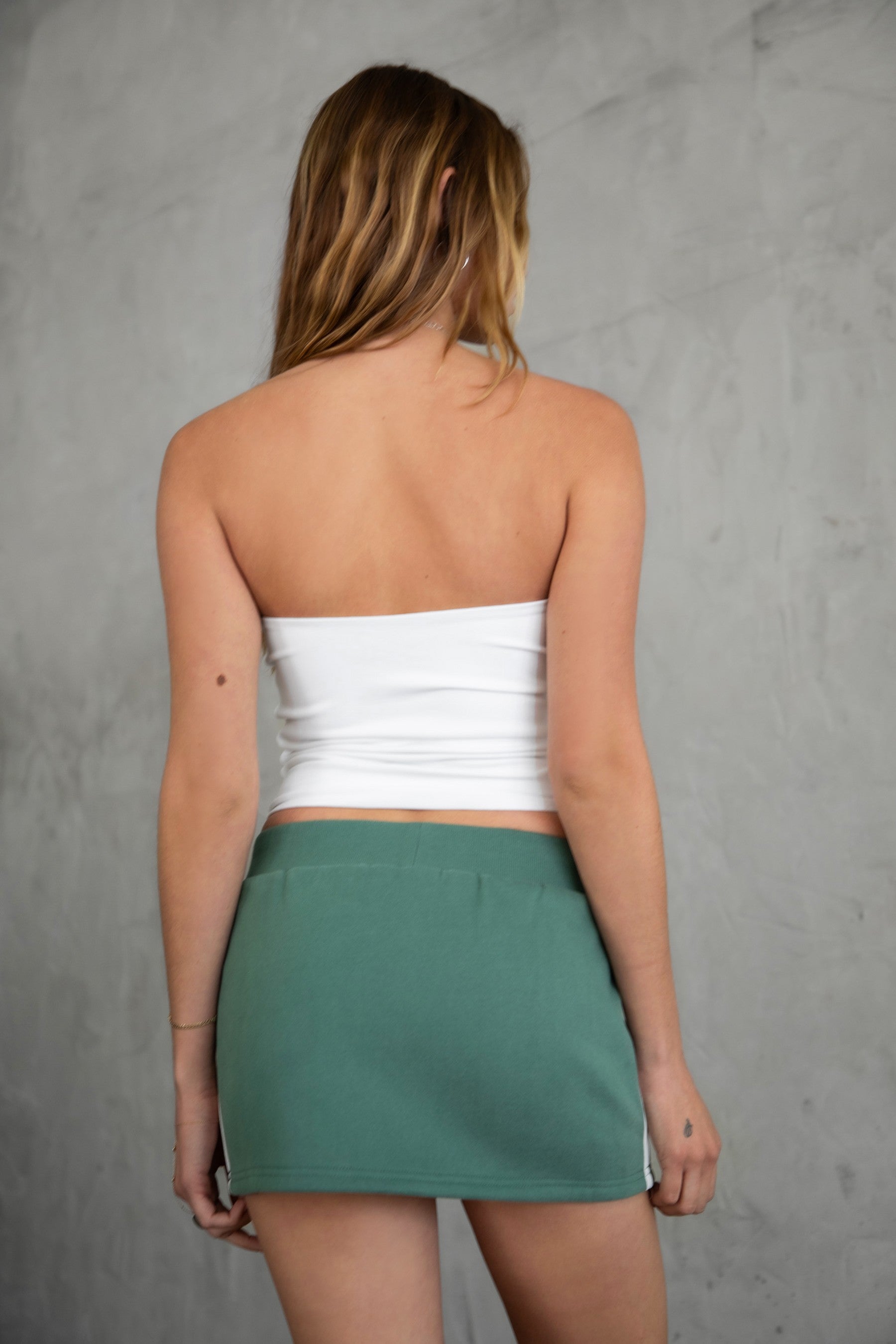 COLBI Essentials Plush Fleece Mini Skort with ribbed tie waistband and contrast piping in pine green.