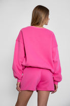 Relaxed fit fleece sweater for women with dropped shoulders and plush cozy fabric in fuchsia