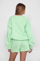 Relaxed fit fleece sweater for women with dropped shoulders and plush cozy fabric in pastel lime