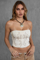 TIC TOC BECKEE PU vegan leather corset top in oatmeal featuring rhinestone details and a distressed finish