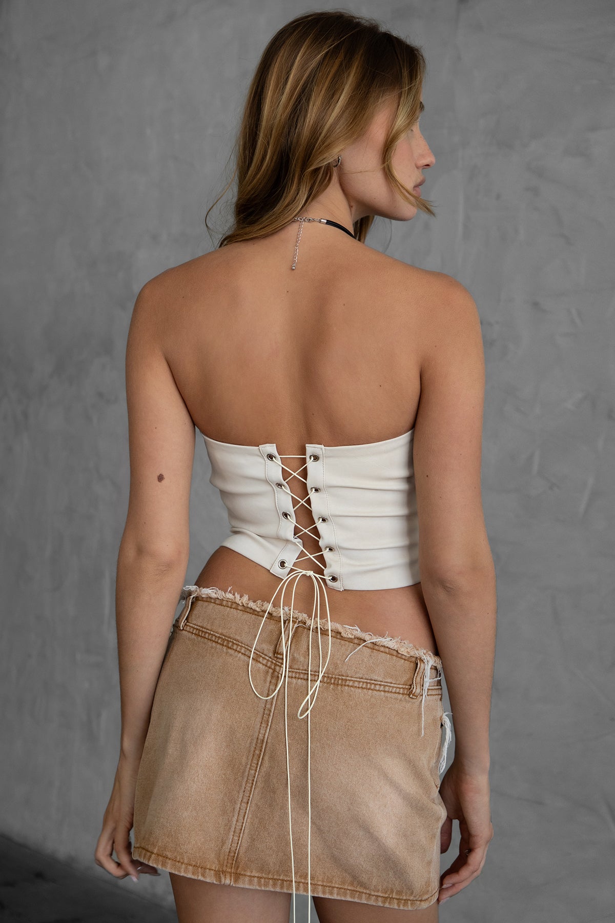 TIC TOC BECKEE PU vegan leather corset top in oatmeal featuring rhinestone details and a distressed finish